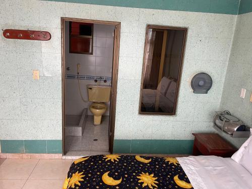 a room with a bed and a bathroom with a toilet at Hotel Brisas Real in Bogotá