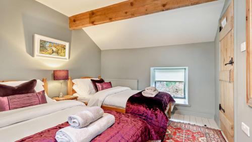 a bedroom with two beds and a window at Hillcrest Barn in Monyash