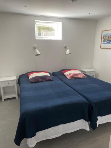 um quarto com uma grande cama azul e 2 almofadas em Sommar på Smögen! em Smögen