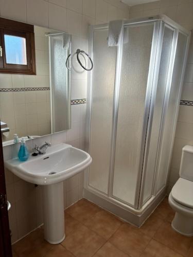 uma casa de banho com um chuveiro, um lavatório e um WC. em Hotel el Cid em Torres de Albarracín