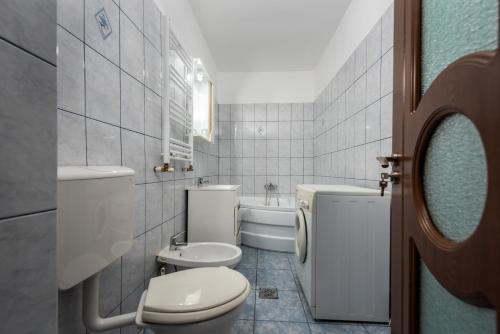 uma casa de banho com um WC, um lavatório e uma banheira em Central Apartament Predeal Nr 1 em Predeal