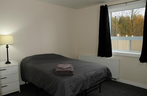 Un dormitorio con una cama con una toalla. en Prospectors Inn en Kirkland Lake