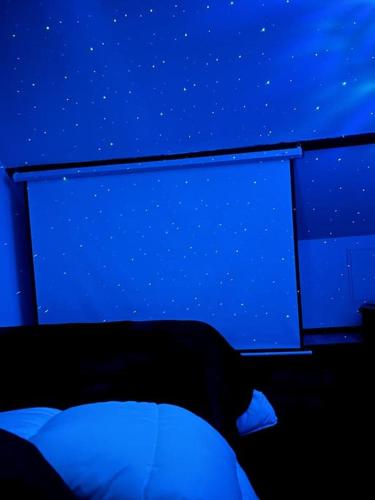 a bed in a room with a blue background at Escapade Cinéma : Duplex 50m² in Linas