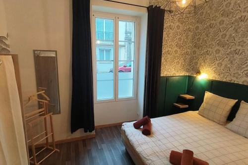 昂古萊姆的住宿－Appartement cosy jardin en ville，一间卧室设有一张床和一个窗口