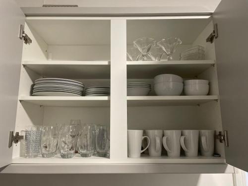 une armoire blanche remplie de vaisselle et de verres dans l'établissement Dinorwic Lodge, à Liverpool
