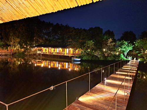 ein Dock mit einem Gebäude auf dem Wasser in der Nacht in der Unterkunft TINA LAKESIDE PHUOC HAI (5 minutes from beach) in Chợ Phước Hải