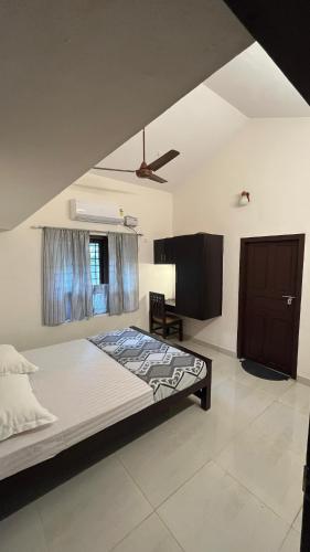 a bedroom with a large bed and a window at The Green Thumb Farm Stay in Mundakāyam
