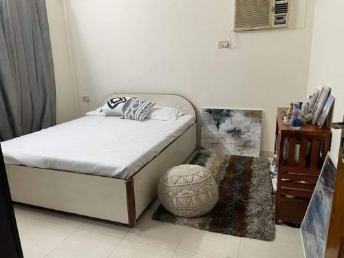 a bedroom with a bed with a ottoman and a table at Bandra west 2bhk in Mumbai