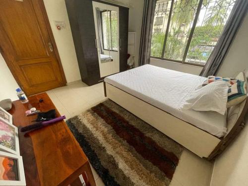 a bedroom with a bed and a window and a rug at Bandra west 2bhk in Mumbai