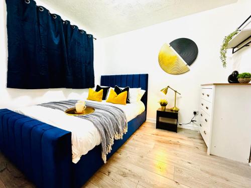 a bedroom with a blue bed with yellow pillows at Rooms Near Me - Central Birmingham Free Parking in Birmingham