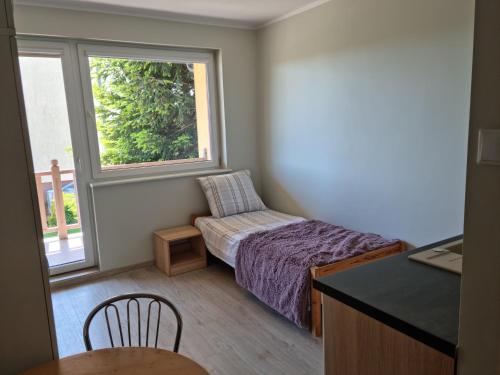 a small bedroom with a bed and a window at Pod Cisem in Kierzkowo