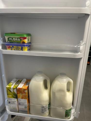 a refrigerator with milk and other food items in it at Dinorwic Lodge in Liverpool