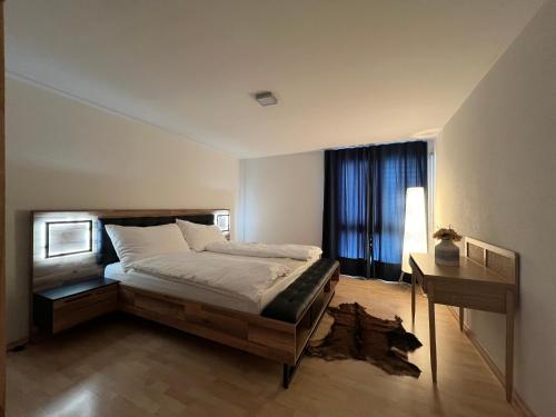 a bedroom with a bed and a desk and a window at Spacious Cozy 2 Bedroom Apartment near Aegerisee in Oberägeri