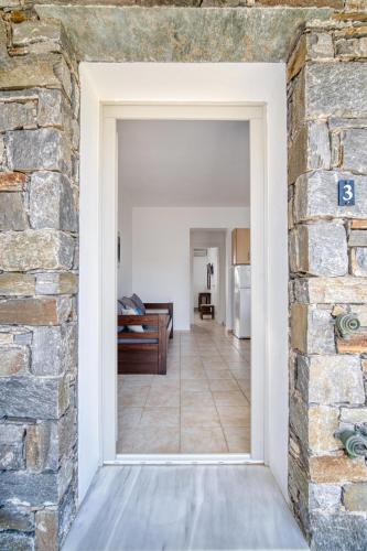 an open door into a living room with a stone wall at Palos Studios in Livadion