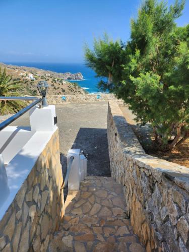 a stone wall with a stairs leading down to the ocean at Villa Stephania in Spílion