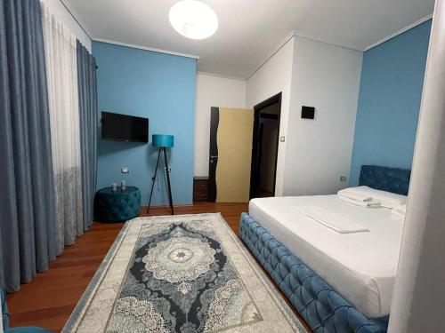 a bedroom with blue walls and a bed with a rug at Bora Hotel in Gjirokastër