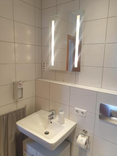 a white bathroom with a sink and a mirror at Landhaus Bad Rotenfels - Bethel in Gaggenau