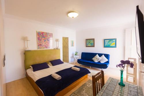 a bedroom with a bed and a blue chair at Ocean Breeze Bloubergstrand in Bloubergstrand