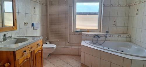 ein Badezimmer mit einer Badewanne, einem WC und einem Waschbecken in der Unterkunft Hotel Boizenburger Hof in Boizenburg
