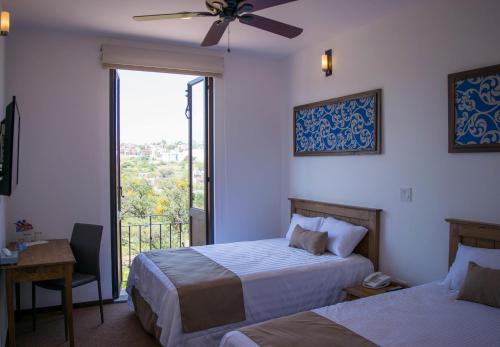 a hotel room with two beds and a window at Hotel La Estación in San Miguel de Allende