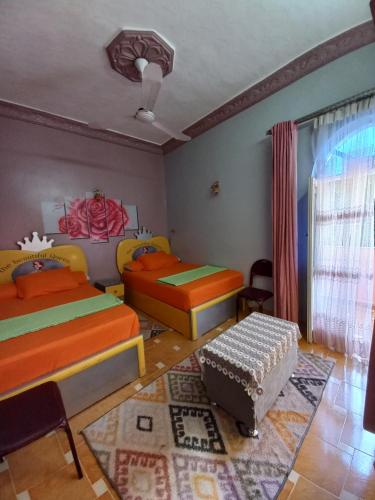 a bedroom with two beds and a table at charming nubian guest house in Aswan