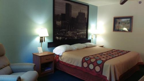 a hotel room with a bed and a chair at Super 8 by Wyndham Thurmont in Thurmont