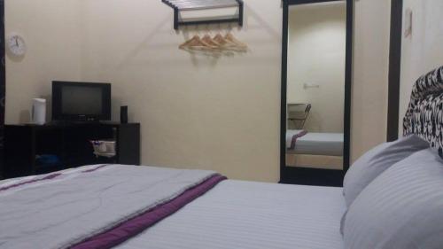 a bedroom with a bed and a mirror and a television at GLG KLIA Transit House in Sepang