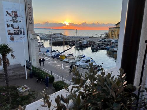 vista para uma marina ao pôr-do-sol a partir de um edifício em Gloria Holiday - Apartment Rebecca em Piran