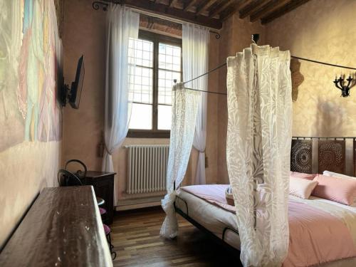 a bedroom with a canopy bed and a window at Luxury Corte dei Nobili in Lucca