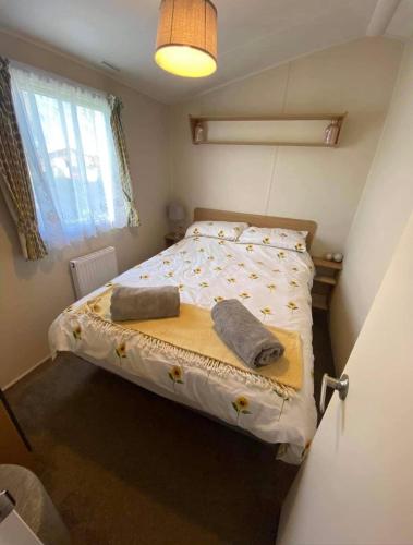Un pequeño dormitorio con una cama con toallas. en LottieLou’s Hot Tub breaks at Tattershall Lakes, en Lincoln