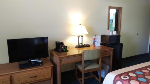 a hotel room with a desk with a television and a bed at Super 8 by Wyndham Thurmont in Thurmont