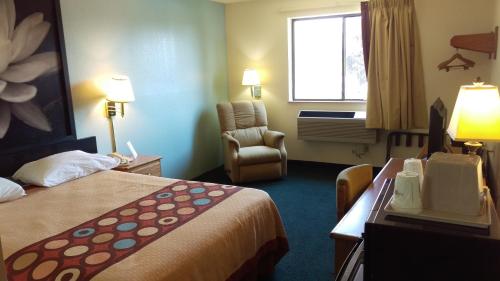 a hotel room with a bed and a chair at Super 8 by Wyndham Thurmont in Thurmont