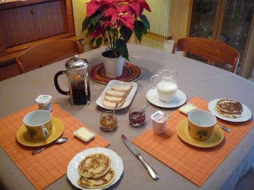ein Tisch mit Tassen und Teller mit Essen drauf in der Unterkunft Au Bon Accueil in Jonzac
