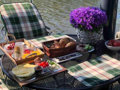 a table with a tray of food and a basket of food at Prachtig guesthouse aan het water in Almere