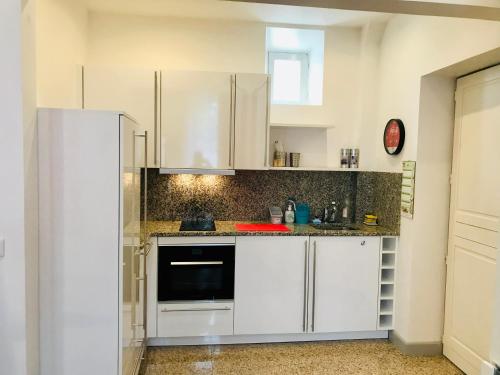 a kitchen with white cabinets and a refrigerator at The Studio Castle in middle of Fontainebleau in Fontainebleau