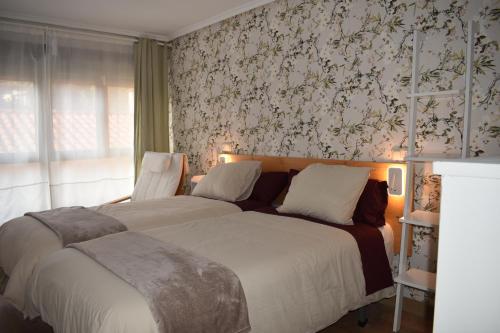 una camera con letto e parete con carta da parati floreale di Casa de Isa VV-2776-AS a Cudillero