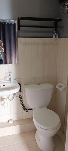 a bathroom with a white toilet and a sink at EL MEIR STAYCATION SMART CINEMA CABIN BESIDE ENCHANTED KiNGDOM in Santa Rosa