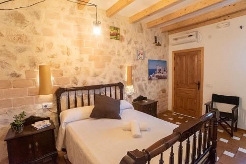 um quarto com uma cama num quarto com paredes de pedra em La Pérgola Habitaciones Rústicas em Es Pujols