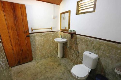 een badkamer met een toilet en een wastafel bij Golden Beach Chalets in Arugam Bay