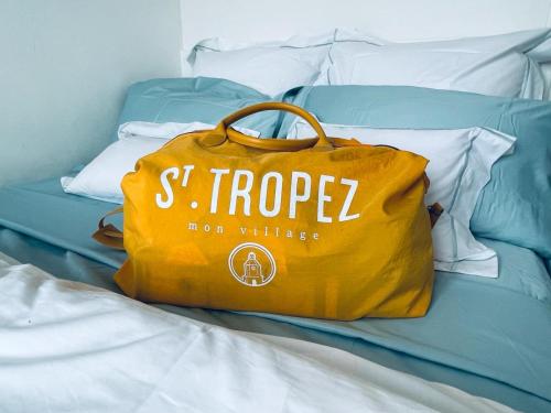 a yellow bag sitting on top of a bed at Luxury Apartment with amazing SEA view at Cap d'Antibes in Antibes