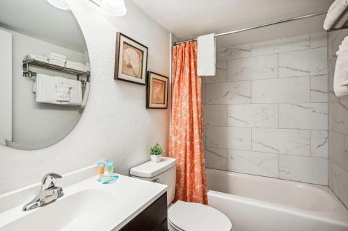 a bathroom with a sink toilet and a mirror at Sand Castle 2901 in Clearwater Beach