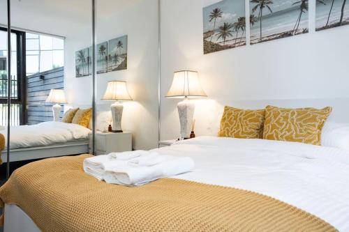 Ένα ή περισσότερα κρεβάτια σε δωμάτιο στο 2 BD Luxury apartment at heart of Docklands with 85" flat TV & Free Carpark