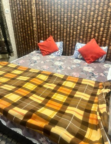 een bed met twee rode kussens erop bij Arora guest house in Amritsar