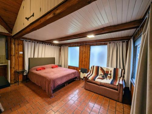 a bedroom with a bed and a chair in a room at EL FURANCHO in San Martín de los Andes