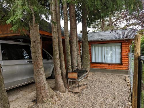 a car parked in front of a house with trees at EL FURANCHO in San Martín de los Andes