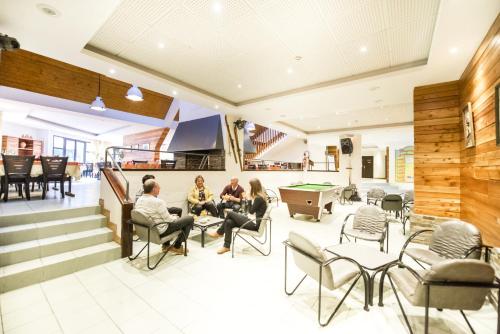 un groupe de personnes assises dans une salle avec un billard dans l'établissement ULVF les Ramondies, à Saint-Lary-Soulan