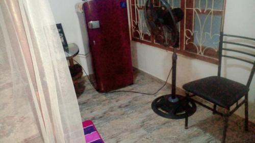 Habitación con silla y nevera roja. en Jayanika home stay, en Tangalle
