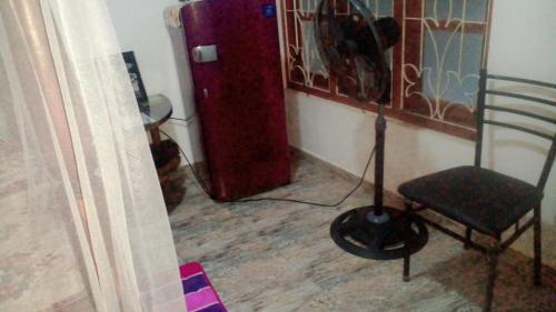 a room with a chair and a red refrigerator at Jayanika home stay in Tangalle
