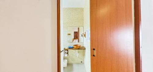 een badkamer met een toilet en een houten deur bij Amazônia Kite Club in Luis Correia