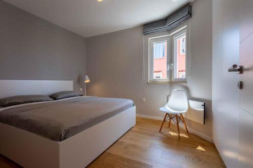 um quarto com uma cama e uma cadeira branca em Apartment in Vrbnik - Insel Krk 45250 em Vrbnik